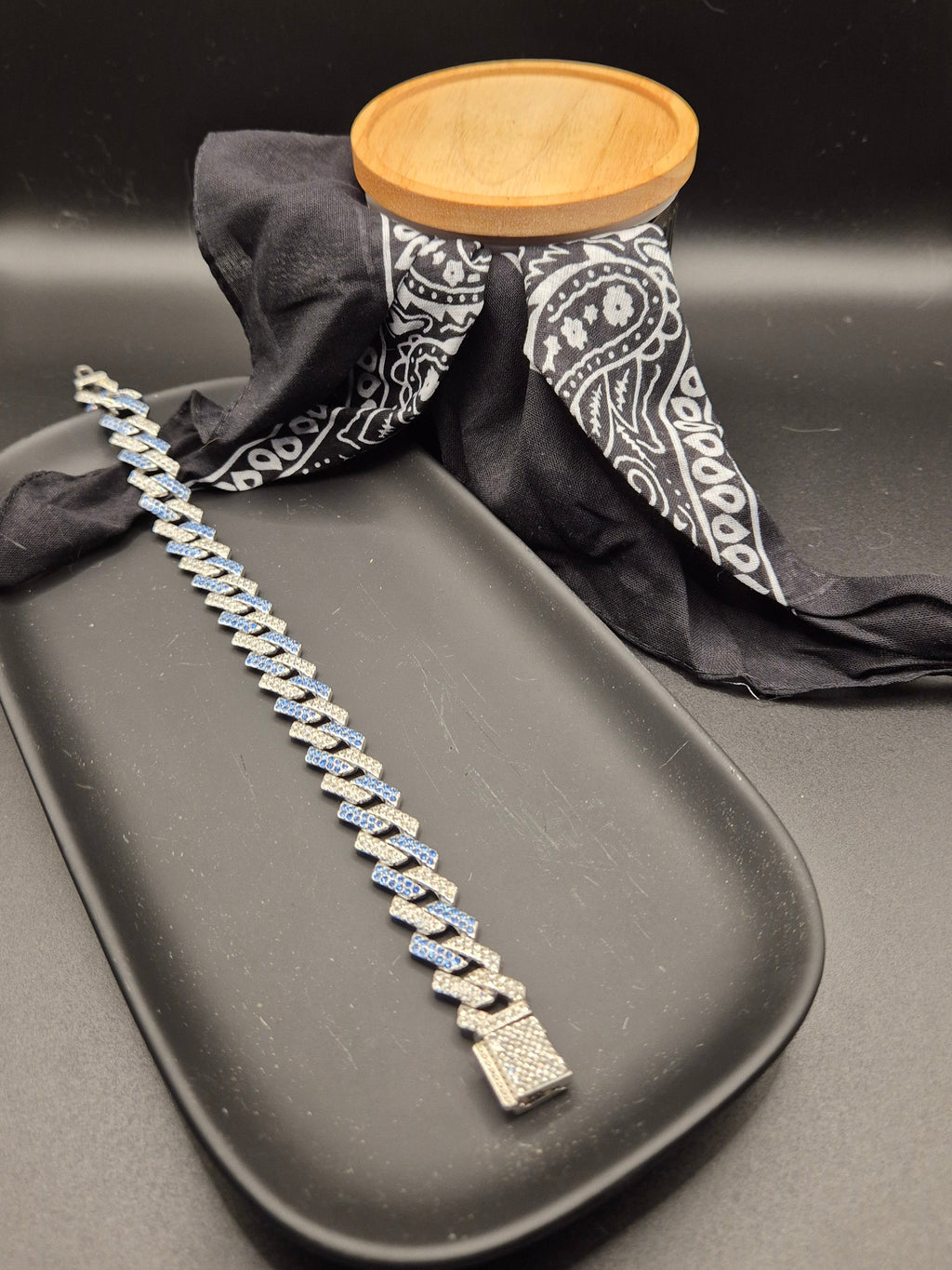 Bracelet on a dark surface with a black bandana and wooden object